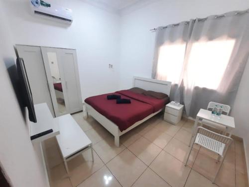 a bedroom with a red bed and a mirror at Cliftin Studio Apartment in Abu Dhabi