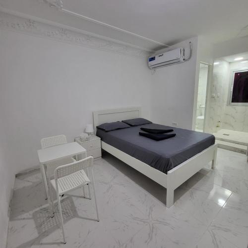a bedroom with a bed and a desk and a table at Cliftin Studio Apartment in Abu Dhabi