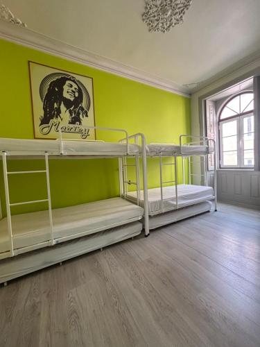 two bunk beds in a room with a green wall at Meeting Hostel in Figueira da Foz