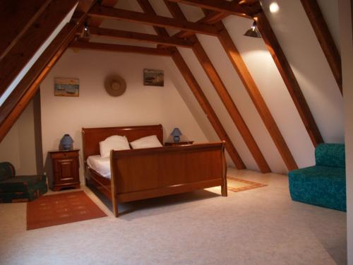 une chambre avec un lit et une chaise dans un grenier dans l'établissement Le Clos de Carmensac, à Meyrals