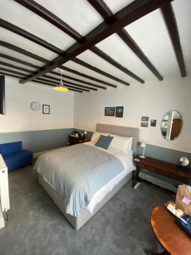 a bedroom with a large bed and a table at Stone's Throw Guest House in Weymouth