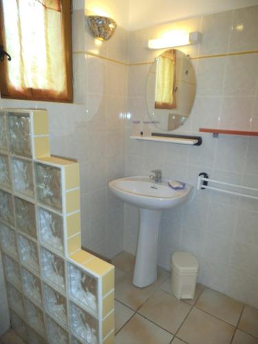 une salle de bain avec un lavabo, des toilettes et un miroir dans l'établissement Le Clos de Carmensac, à Meyrals