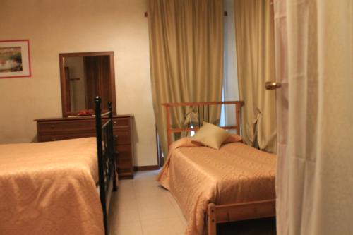 a hotel room with two beds and a mirror at Alice Affittacamere in Cesana Torinese
