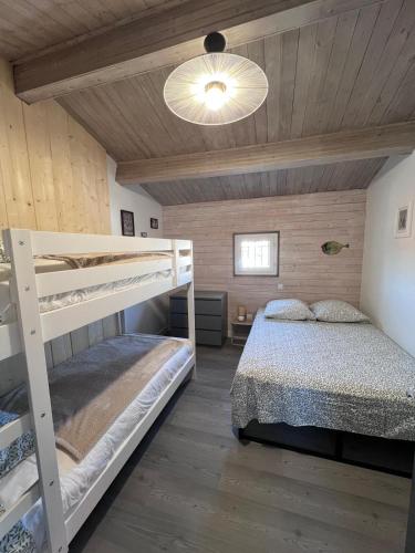a bedroom with two bunk beds and a ceiling at Jolie maison 5 chambres 20 pers in La Tranche-sur-Mer