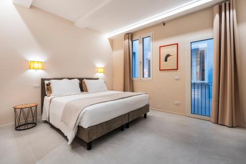 a bedroom with a large bed and two windows at Palazzo Accademia in Florence
