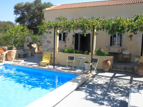 a villa with a swimming pool in front of a house at Stathis Villa in Vamos