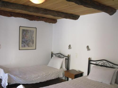 a bedroom with two beds and a wooden ceiling at Stathis Villa in Vamos