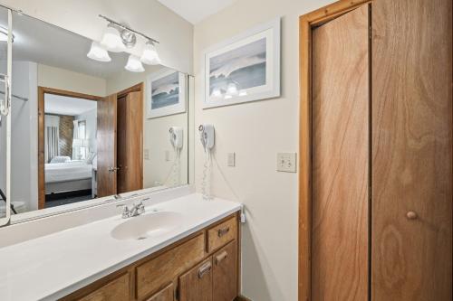 ein Badezimmer mit Waschbecken und Spiegel in der Unterkunft Ocean Pines Resort in Duck