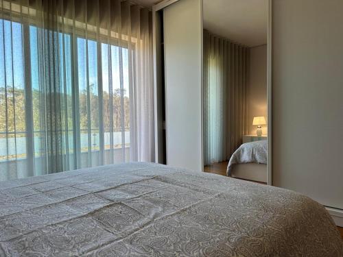 a bedroom with a bed and a large window at Ofir Beach Apartment in Fão