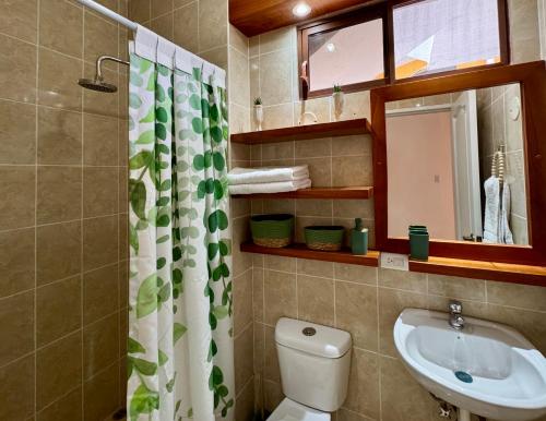 a bathroom with a toilet and a sink and a mirror at BoHo Galapagos in Puerto Ayora