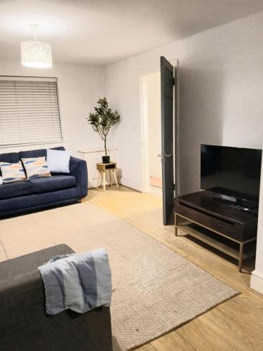 a living room with a couch and a flat screen tv at Modern Coastal Haven Family and Dog friendly in Burry Port