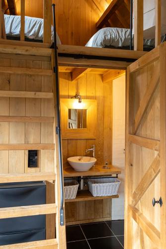 a bathroom with a sink and a bathroom door open at De Zonnebrug in Sint-Laureins