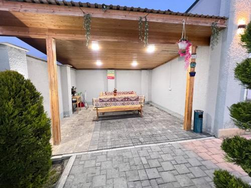 a patio with a wooden pergola and a bench at Rest House İsmayıllı Villa in İsmayıllı