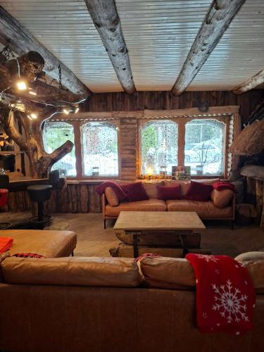 a living room with couches and tables and windows at Finstonia Guesthouse in Vääna-Jõesuu