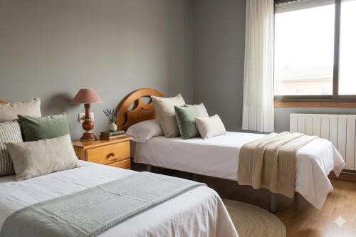 a bedroom with two beds and a window at Precioso chalet cerca de la playa de Samil in Vigo