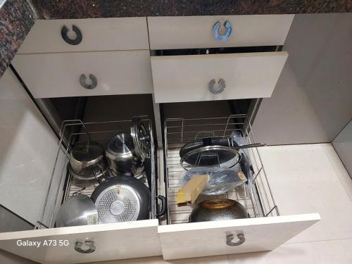 a kitchen drawer with dishes and utensils in it at The Pinnacle Retreat , Jaitala in Nagpur