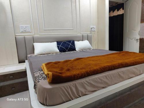 a bed with a brown blanket on top of it at The Pinnacle Retreat , Jaitala in Nagpur