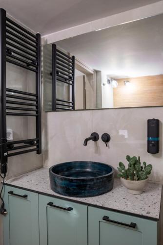 un lavabo de salle de bain avec une vasque en verre bleu sur un comptoir dans l'établissement Valtinon Smart Corner, à Athènes
