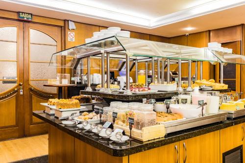 ein Buffet mit Speisen auf einem Tisch in der Unterkunft Ritter Hotéis - Em frente à Rodoviária de Porto Alegre in Porto Alegre