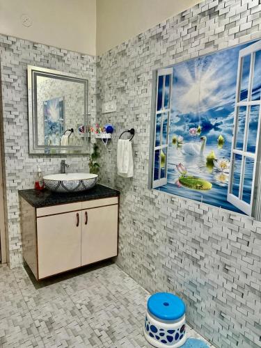 a bathroom with a sink and a painting on the wall at Palash Paradise in Bokāro
