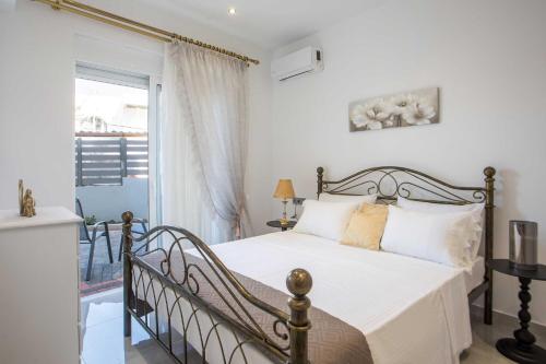 a bedroom with a bed and a balcony at Hara's Cozy Apartment with Private Parking in Rhodes Town