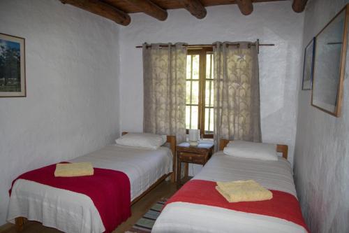 two beds in a room with a window at Casa Chueca - DiVino in Talca