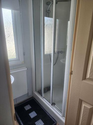 a shower with a glass door in a bathroom at 2 Vale Park in Fishguard