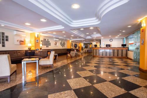 a lobby with a waiting room with couches and chairs at Hotel Metropolitan Canoas in Canoas