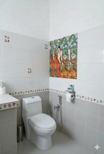 a bathroom with a toilet and a painting on the wall at SEVEN Guesthouse in Thong Sala