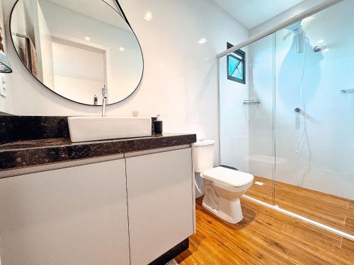 a bathroom with a sink and a mirror at Flat moderno com churrasqueira próximo à Unifebe in Brusque