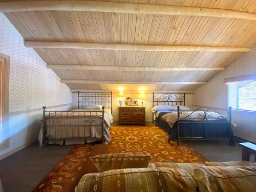 a bedroom with two beds and a wooden ceiling at Selway View Cabin in Corvallis
