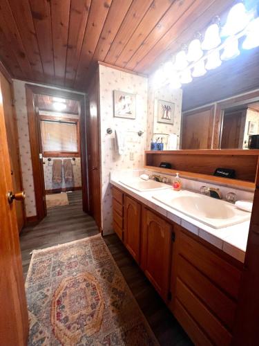 a bathroom with two sinks and a large mirror at Selway View Cabin in Corvallis