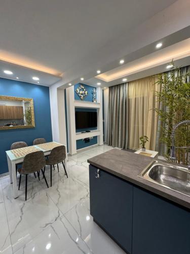 a kitchen with a sink and a table with chairs at B&S Accommodation Newly Renovated Penthouse 253 in Żejtun