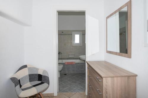 a bathroom with a sink and a mirror and a chair at Sunset 7.59 in Mikonos