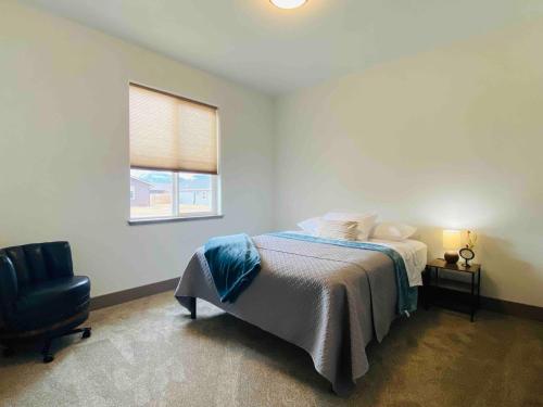 a bedroom with a bed and a chair and a window at Comfy 4 Bdrm House with Air Conditioning in Corvallis