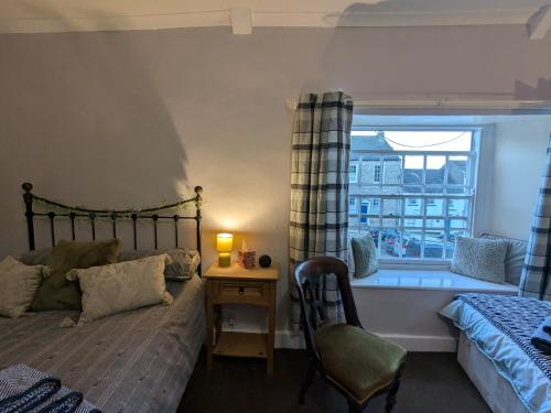 a bedroom with a bed and a window with a bath tub at The Unicorn Inn in Richmond