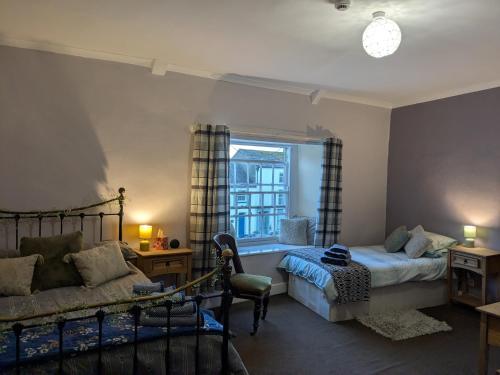 a bedroom with a bed and a couch and a window at The Unicorn Inn in Richmond