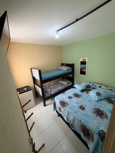 a bedroom with a bed and a bunk bed at Pousada Extensão Sabrinna in Maceió