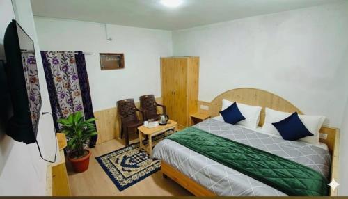 a bedroom with a bed and a tv in it at CL Villa Manali in Manāli