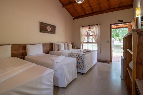 a bedroom with two beds and a window at Pousada Pé na Terra in Brotas