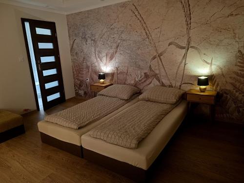 a bedroom with two beds and two lights on the wall at Przystanek Rozkochów in Rozkochów