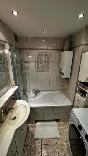 a bathroom with a bath tub and a sink at Cracow View Rooms in Krakow