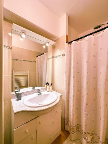 a bathroom with a sink and a shower curtain at Mediterranean Garden in Agde