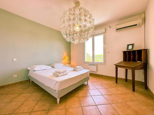 a bedroom with a bed and a chandelier at Mediterranean Garden in Agde