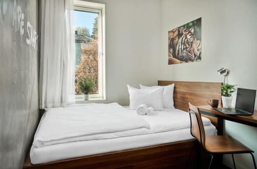a bedroom with a bed and a desk and a window at Smarthotel Tromsø in Tromsø