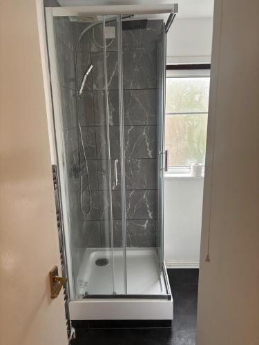 a shower with a glass door in a bathroom at Your choice apartment in Shirehampton