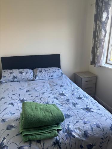 a bed with a green pillow on top of it at Your choice apartment in Shirehampton