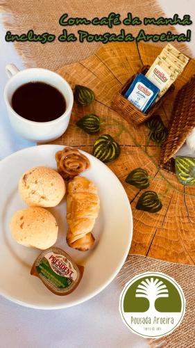 a plate of food with bread and a cup of coffee at Casa Aroeira Sahy in Barra do Sahy