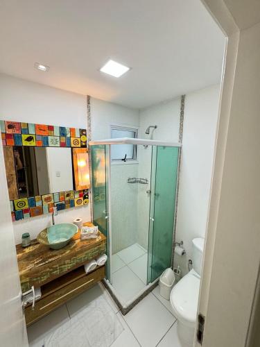a bathroom with a glass shower and a toilet at PRAIA DO FORTE ALTO LUXO in CFB