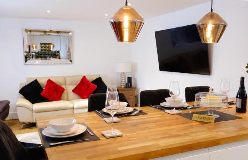 a dining room with a table and a couch at Modern Central St Albans Maisonette Free Parking Sleeps 4 Fast Wifi in St. Albans